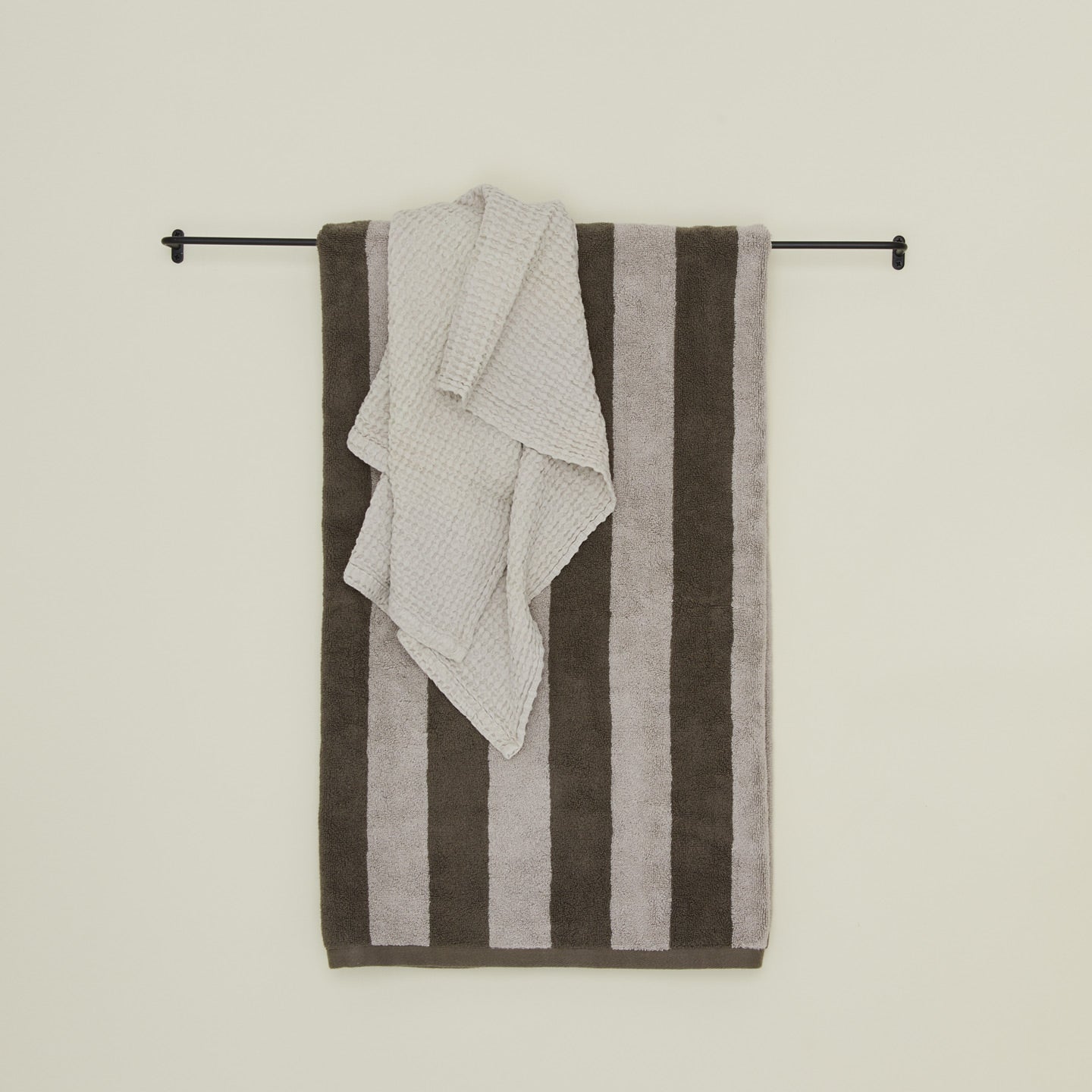 Large iron towel bar with striped terry towel and waffle hand towel