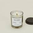 A close up of a lit wax candle with the scent Deep Forest.