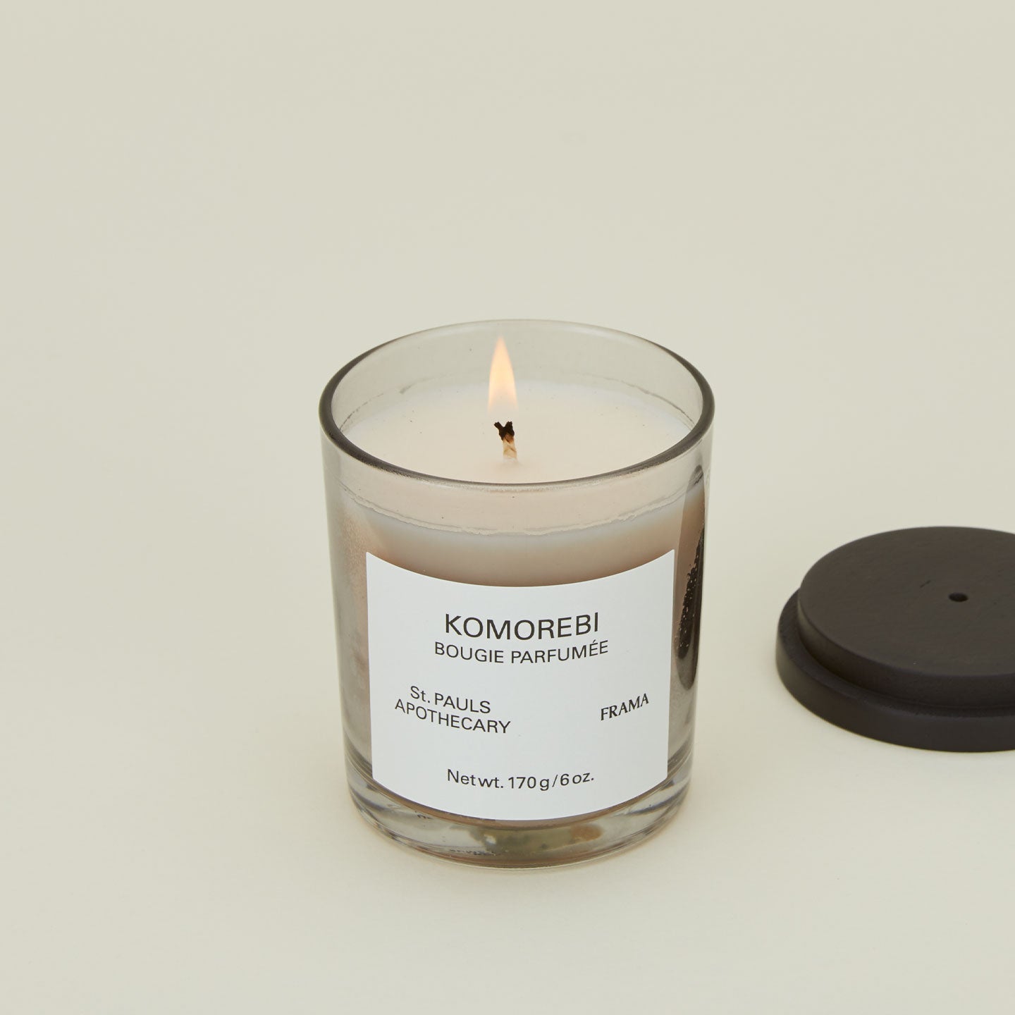 A close up of a lit wax candle with the scent Komorebi.