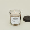 A close up of a lit wax candle with the scent Komorebi.