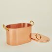 Three quarter view of open copper bread box with lid on ivory background.