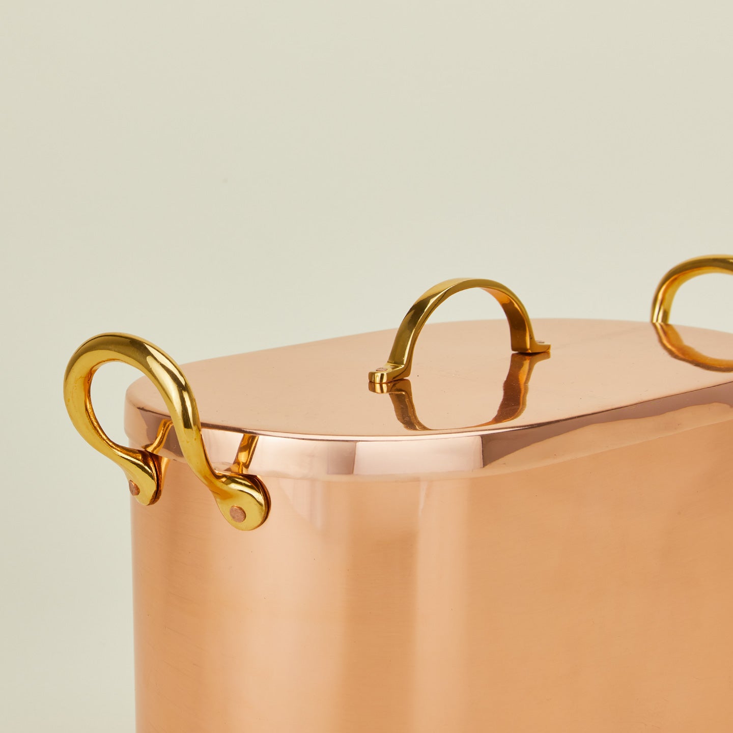 Close up of copper bread box with lid on ivory background.