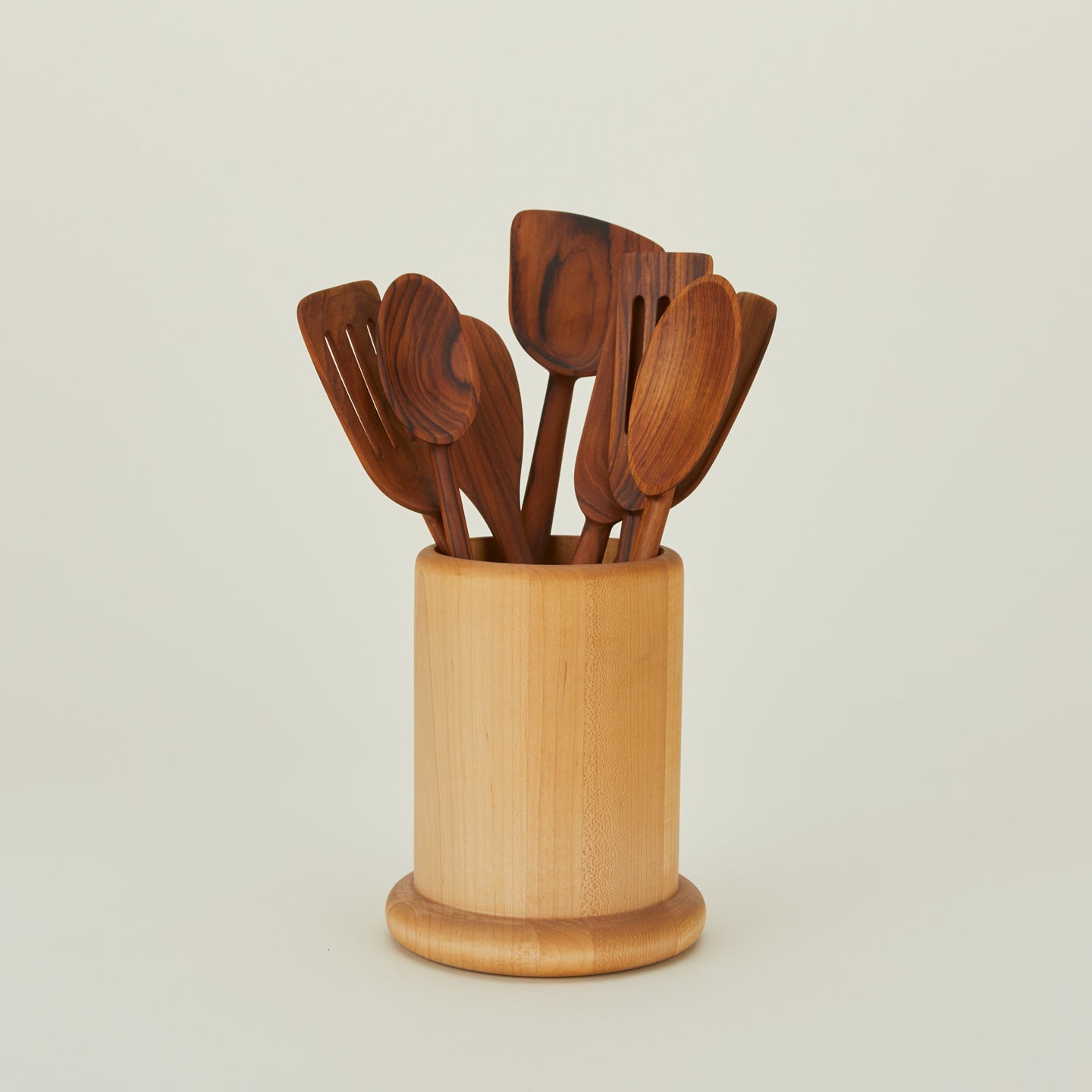 Teak utensil family in wooden crock.