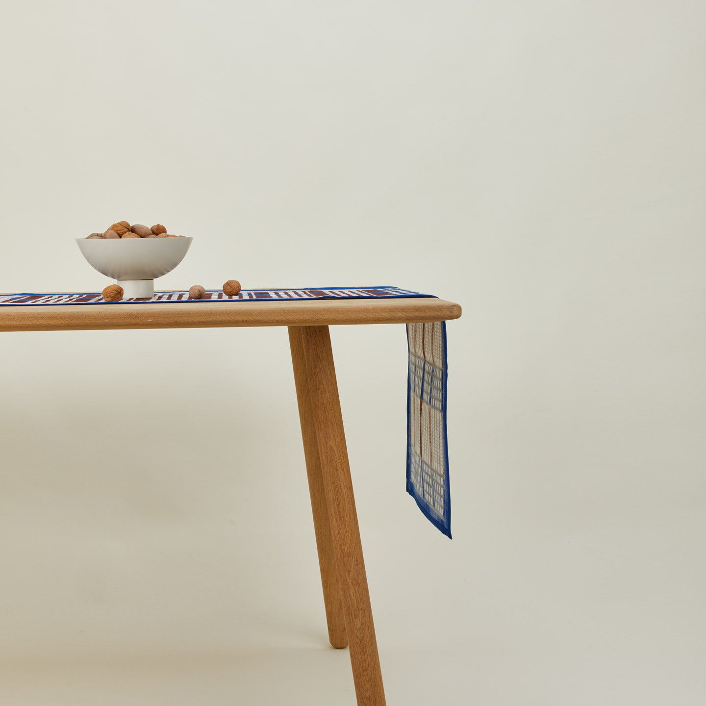 Inner Child Shetland plaid table runner on table with nuts in essential footed bowl.