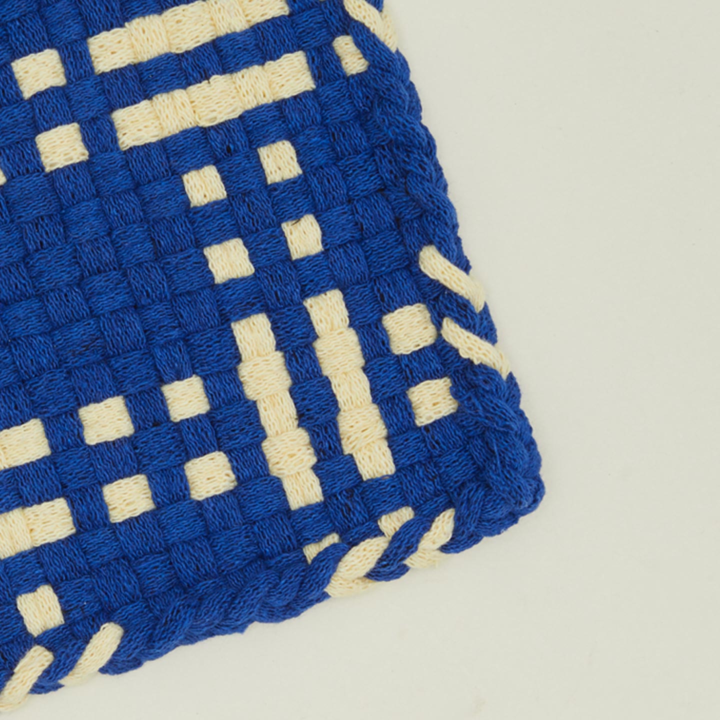 Detail view of dots and dashes potholder in blue and yellow
