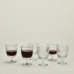Six Ouessant wine glasses, some with wine.