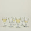 Six Perigord wine glasses, some with wine.