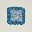 A ruffled floral cushion with an evergreen pattern.
