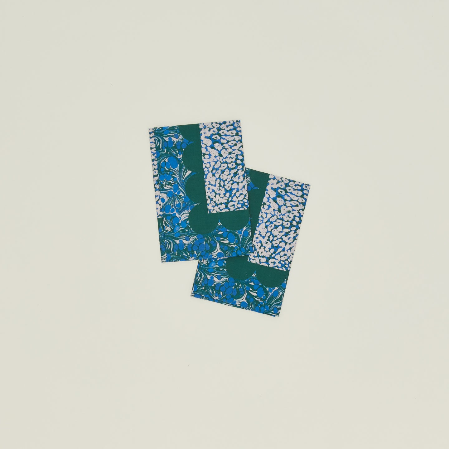 A set of two mixed floral napkins with an evergreen pattern.