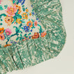 A close up of a ruffled floral cushion with a fern pattern.