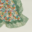 A close up of a mixed floral napkin with a fern pattern.