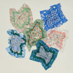 Six loosely wrinkled patterned napkins.