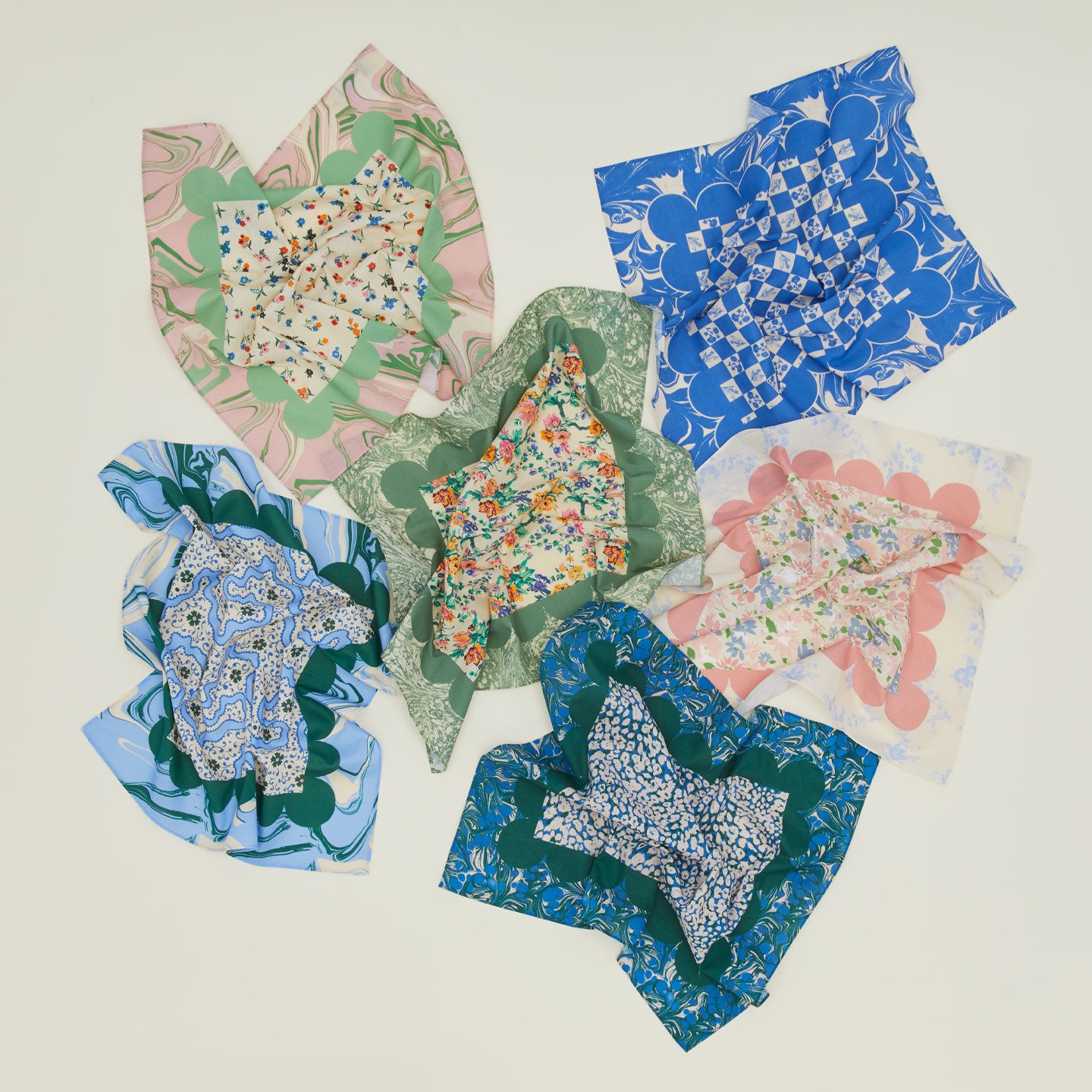 Six loosely wrinkled patterned napkins.