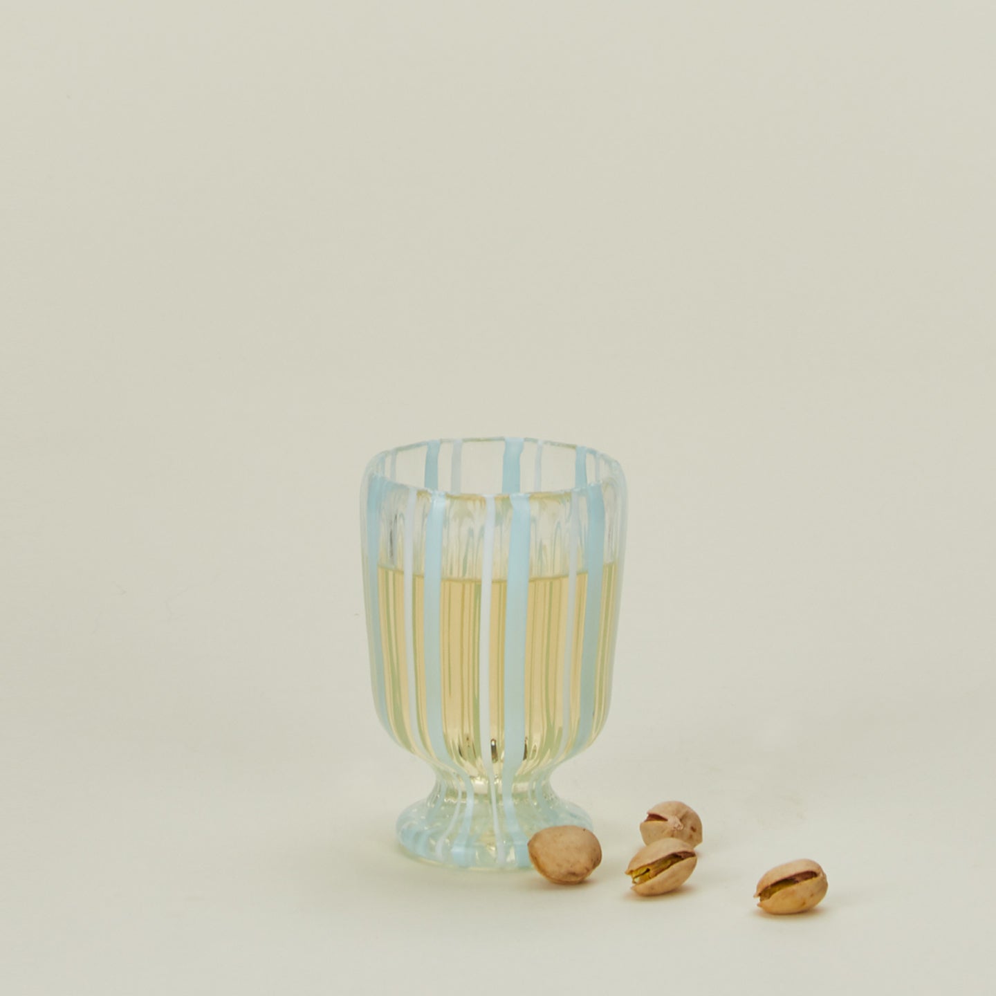 White striped wine glass with pistachios