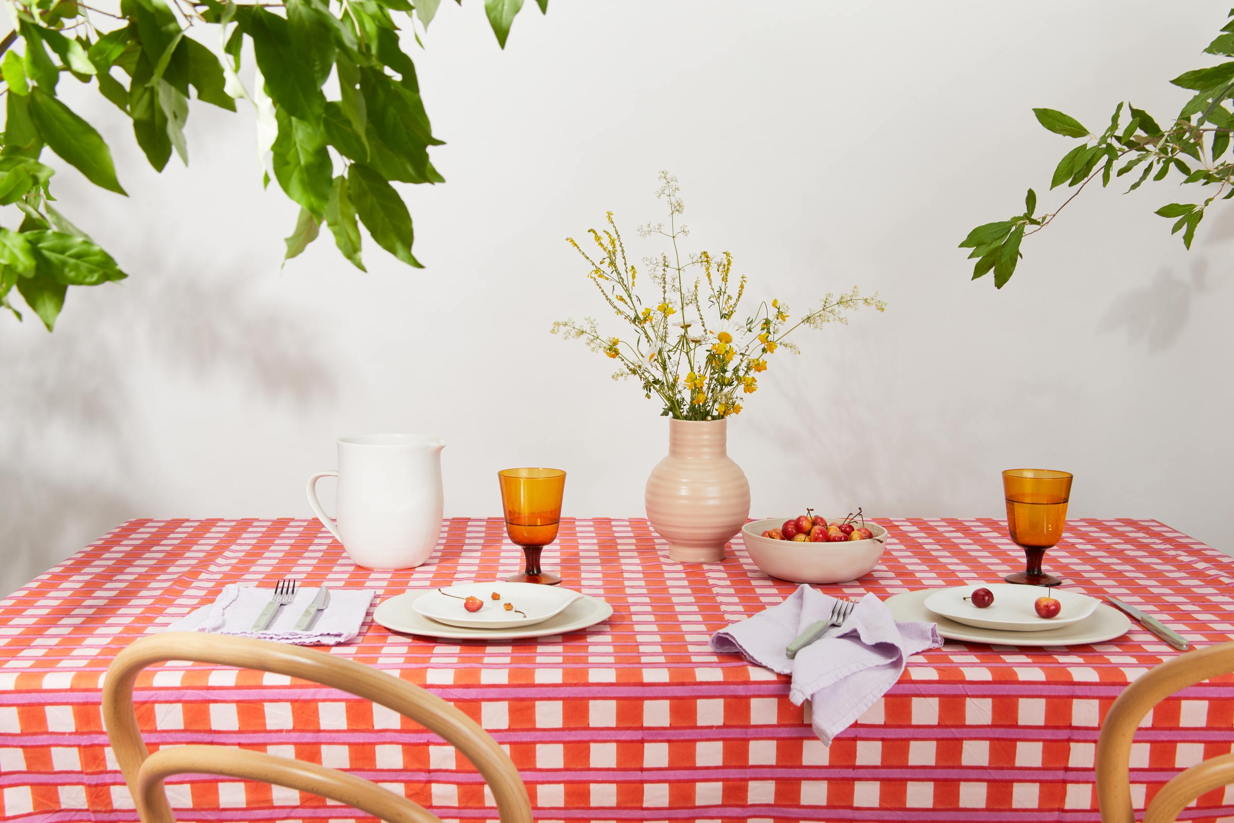 Outdoor table setting with cherries on a ceramic plate. 