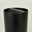 Close up view of lidded wooden waste basket in dark