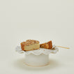 Ruffle edge pedestal with cake and server