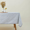 Little flowers rectangular tablecloth in blue on table with flowers in vases.