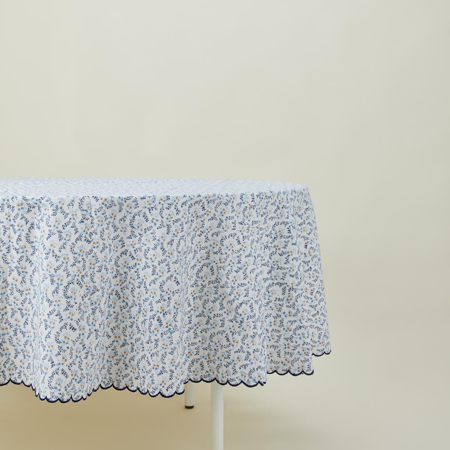Little flowers round tablecloth in blue on table.