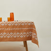 Napa tablecloth in mustard on table with pitcher, glasses, and candy.