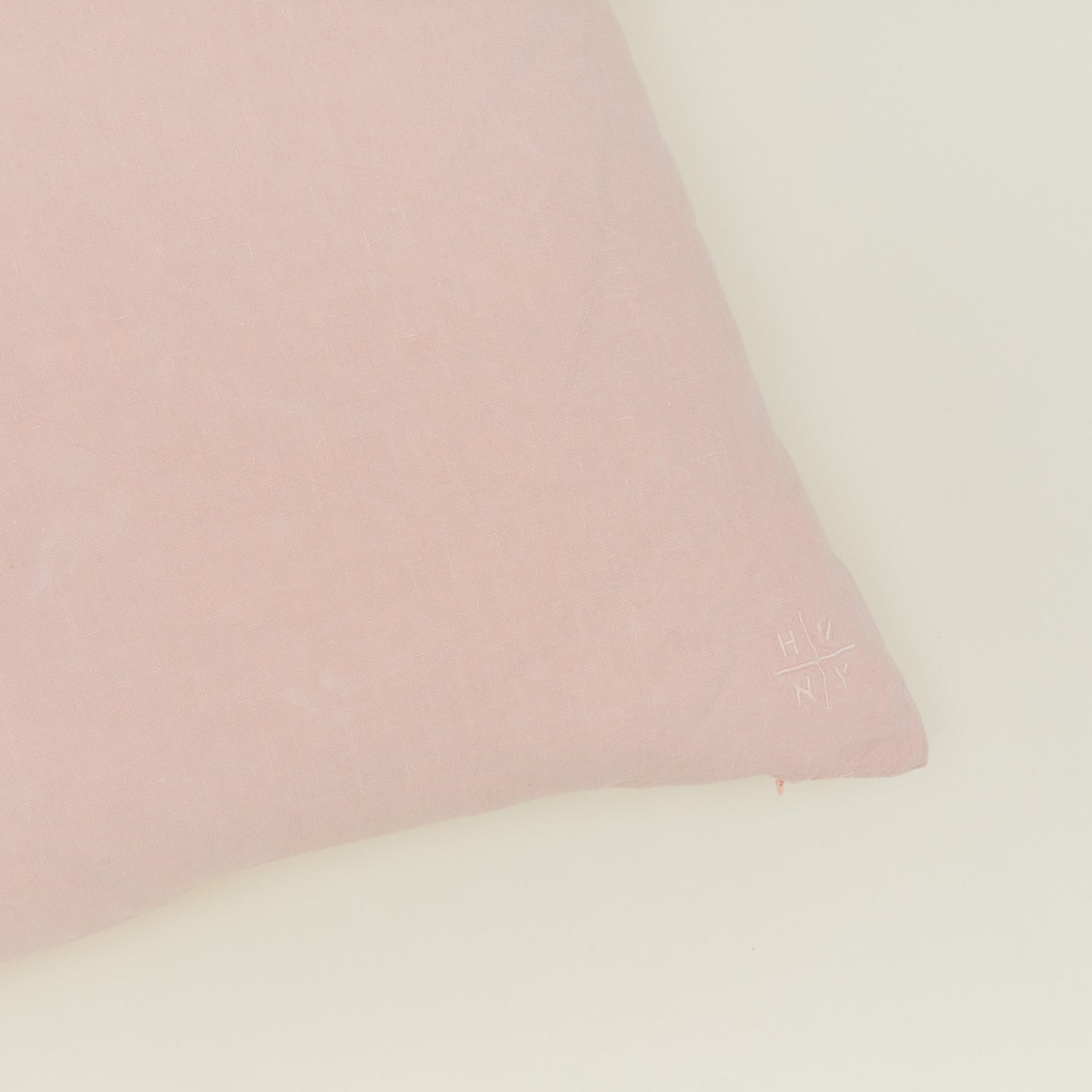 Close up view of simple linen pillow in blush