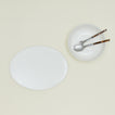 Overhead view of simple porcelain serving set with utensils