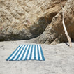 A striped sky and peacock terry towel at the beach.