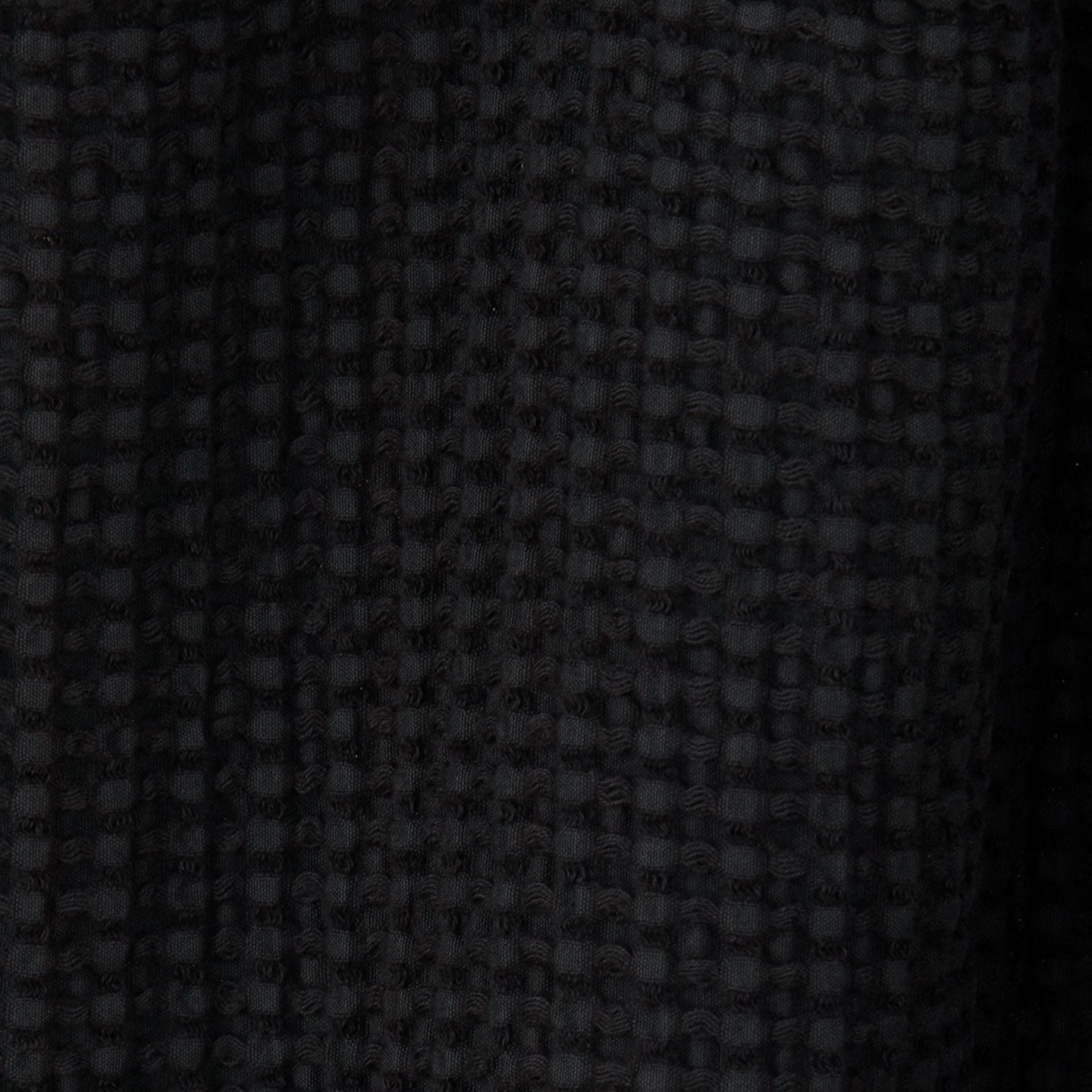 Close up view of simple waffle shower curtain in black