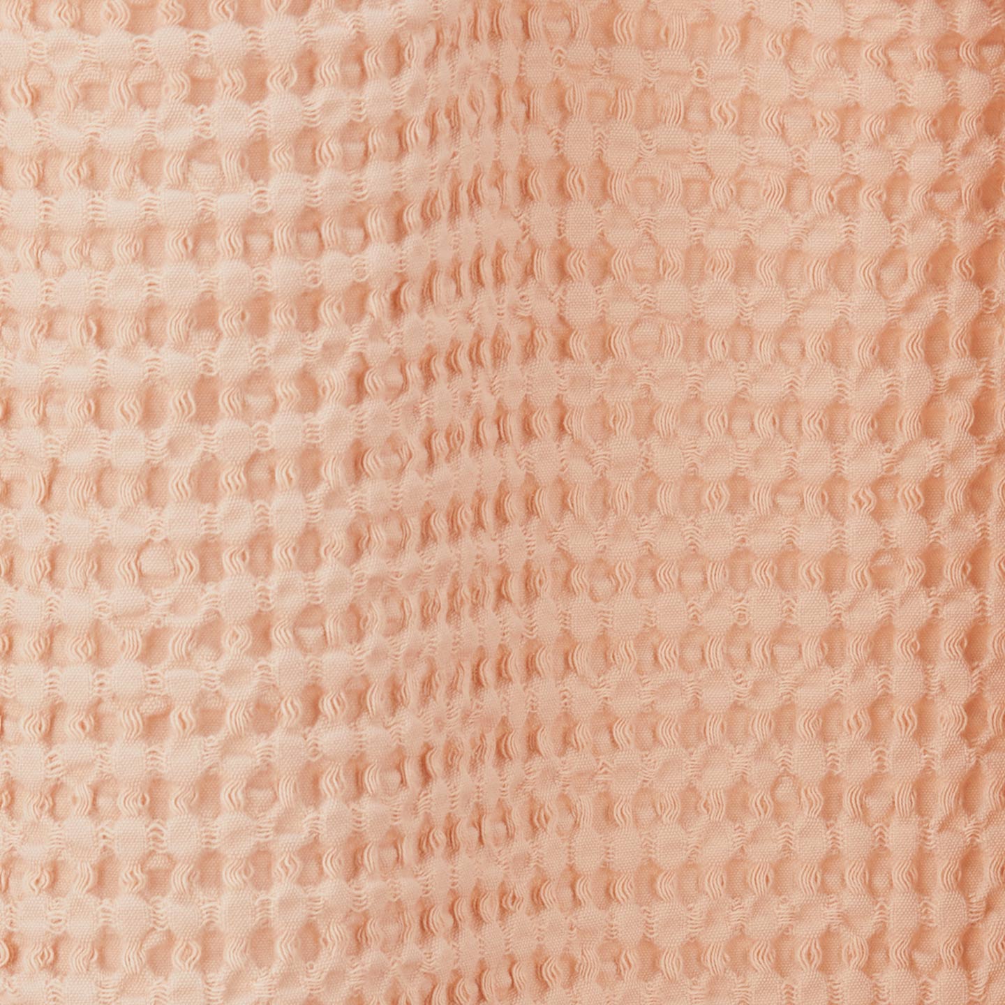 Close up view of simple waffle shower curtain in blush
