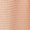 Close up view of simple waffle shower curtain in blush