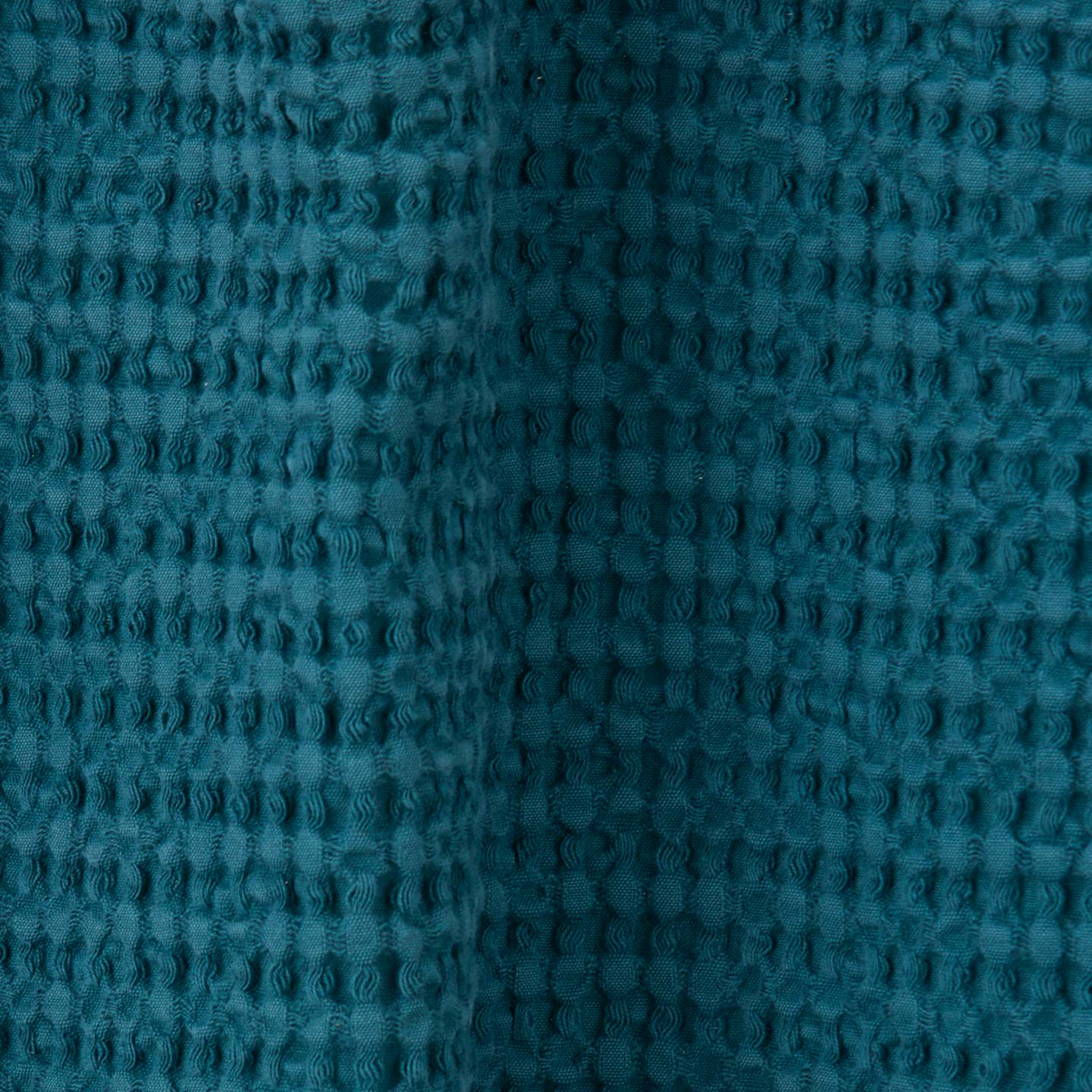 Close up view of simple waffle shower curtain in peacock