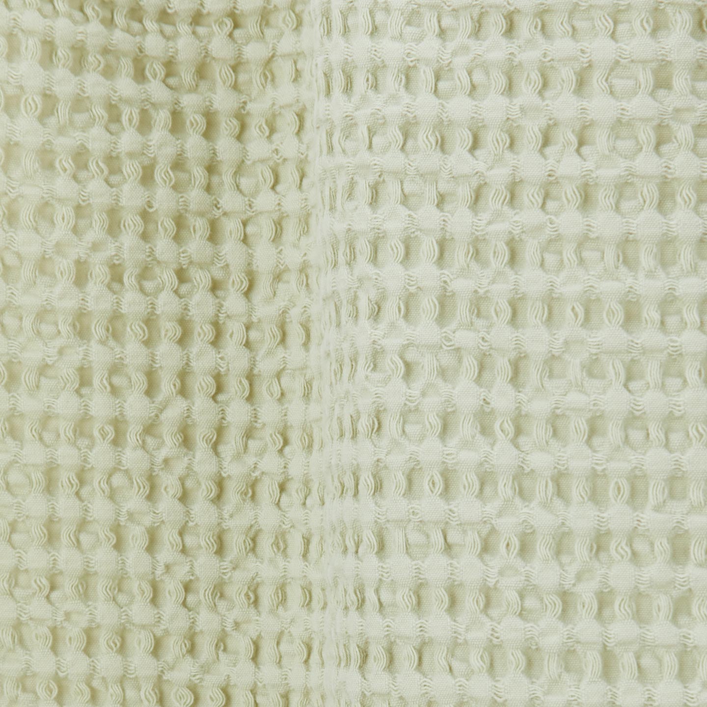 Close up view of simple waffle shower curtain in sage.