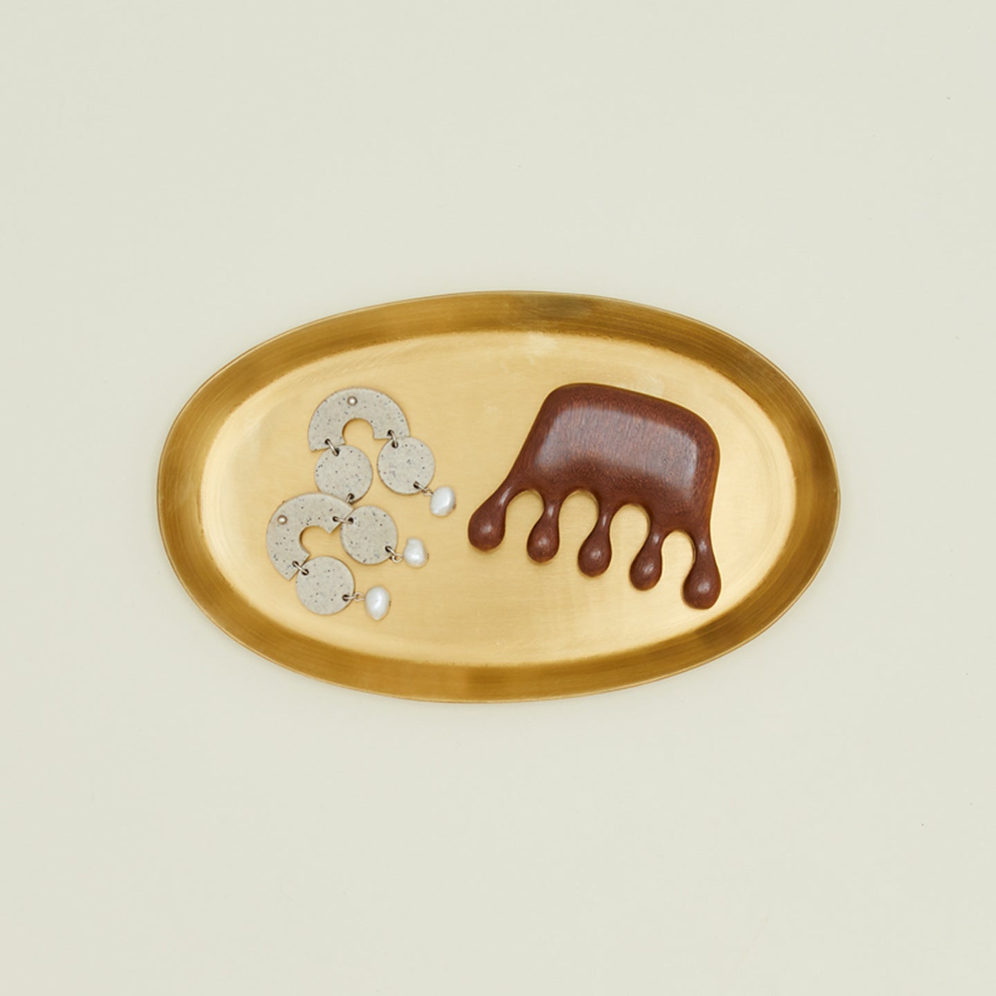 Smile Boutique sandalwood scalp massager on brass tray with earrings