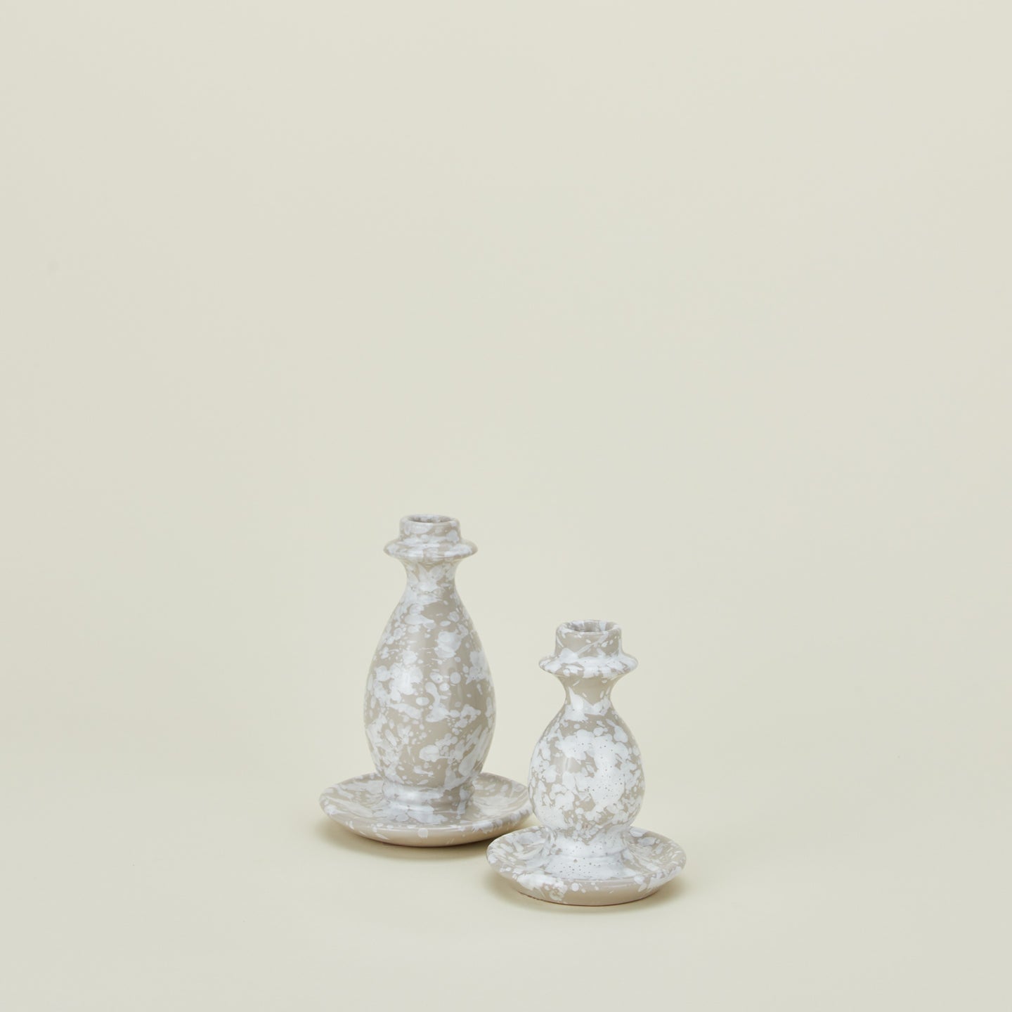 Large and small splatterware candlesticks in white and grey