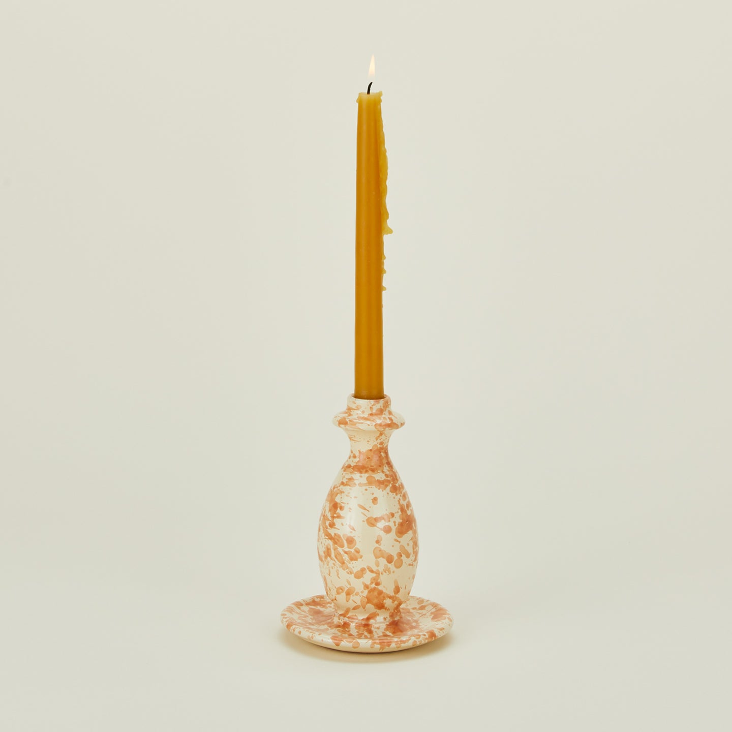 Large splatterware candlestick holder in ivory and bronze with candle