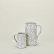 Large and small splatterware pitchers in grey and white