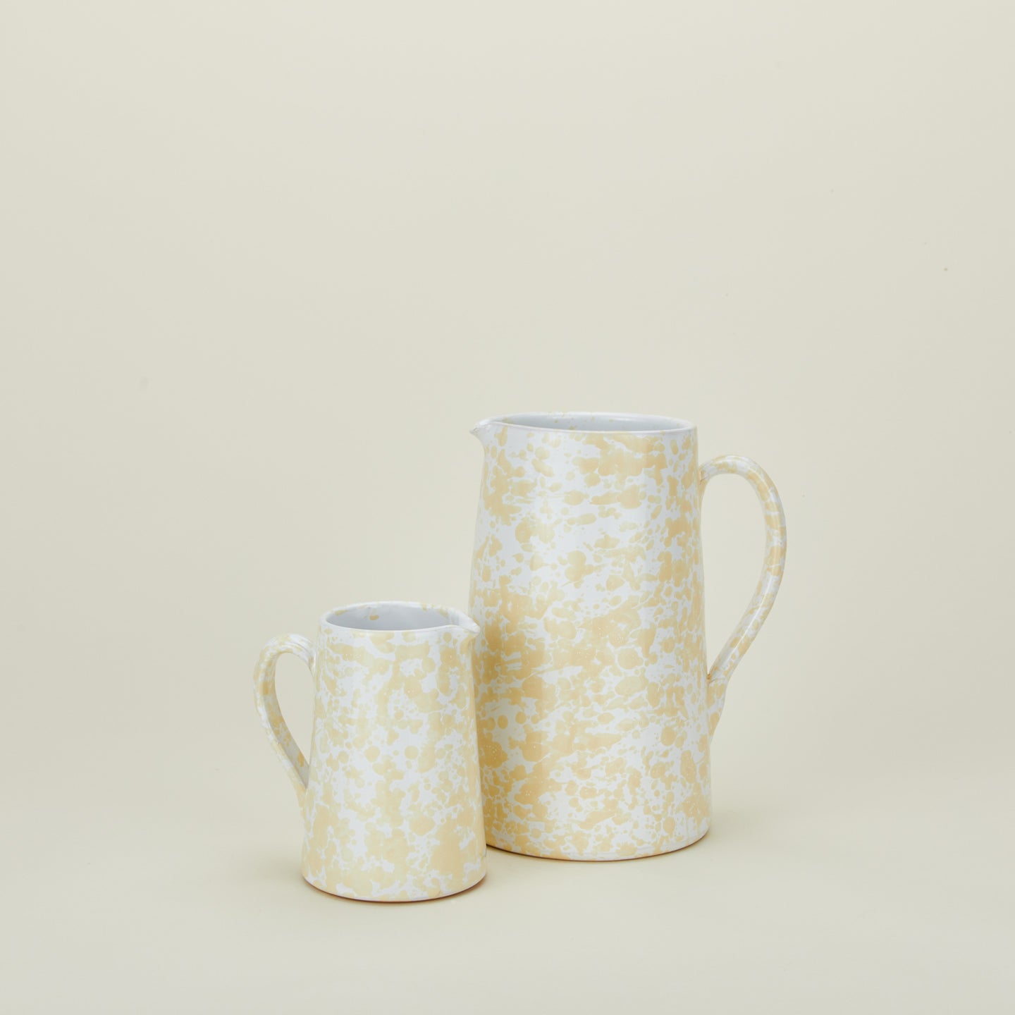 Large and small splatterware pitchers in ivory and white