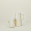 Large and small splatterware pitchers in ivory and white