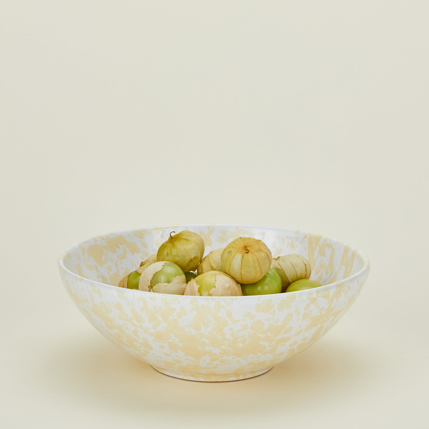 Splatterware serving bowl in white and ivory with tomatillos
