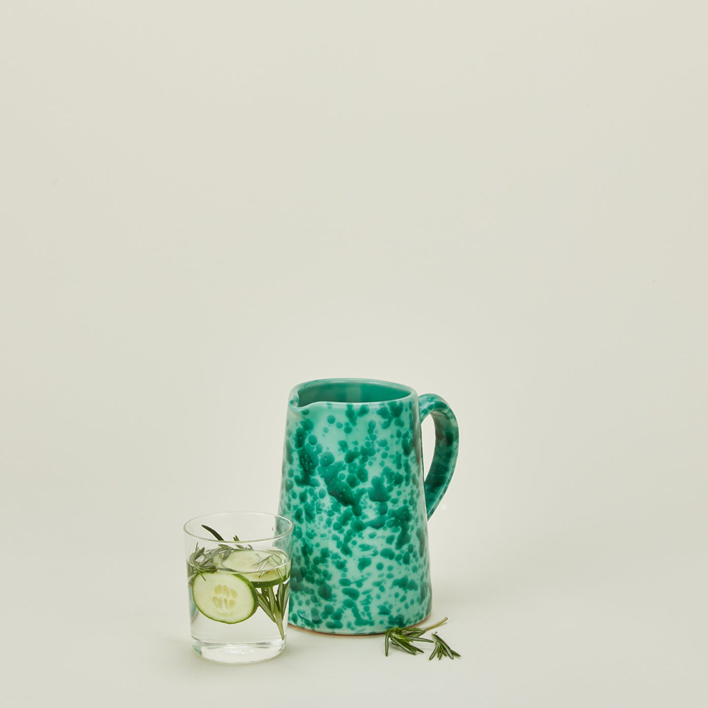 Small splatterware pitcher in sage and green with glass