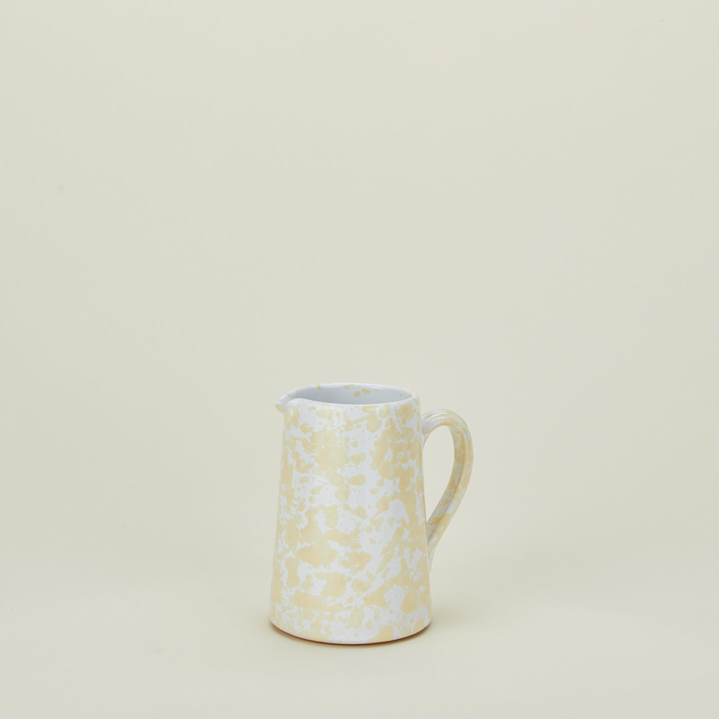 Small splatterware pitcher in white and ivory
