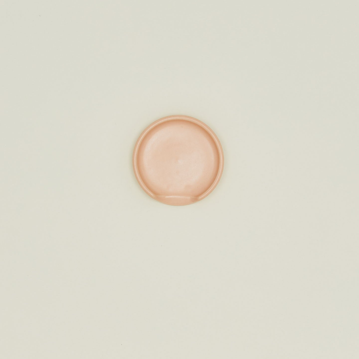 An overhead of a blush stoneware spoon rest.
