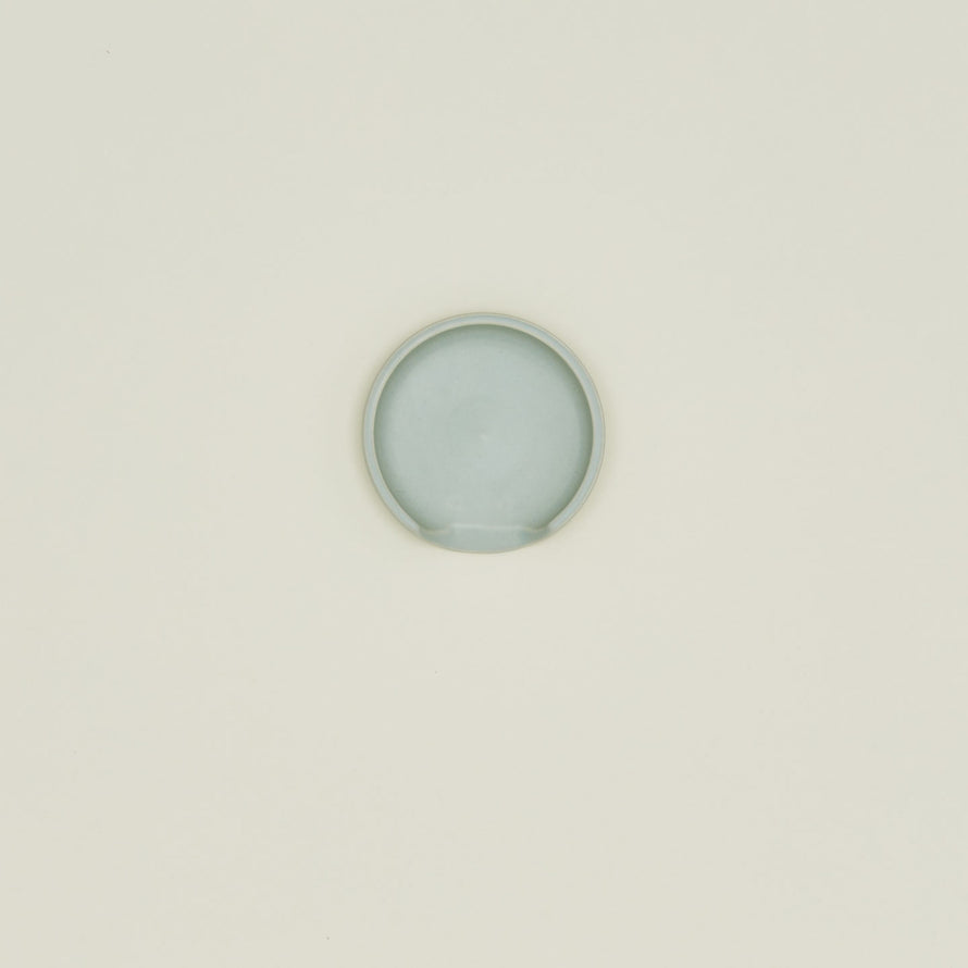 An overhead of a seafoam stoneware spoon rest.