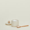 Speckled salt cellar with lid off and wooden spoon