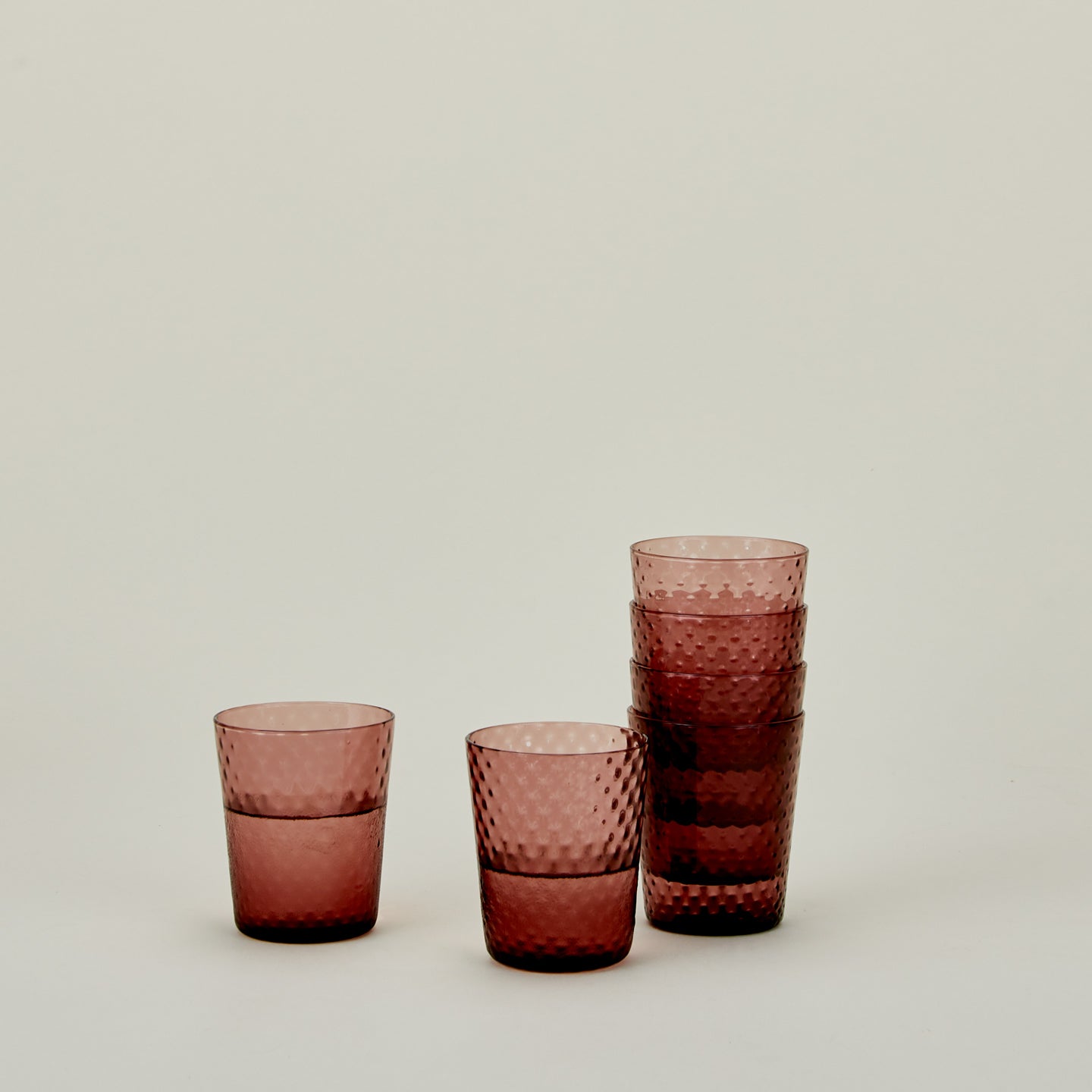 Set of 6 Veneziano Tumblers in Amethyst, stacked, with water.
