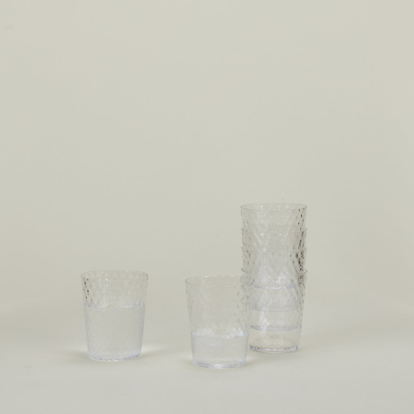 Set of 6 Veneziano Tumblers in Clear, stacked, with water.