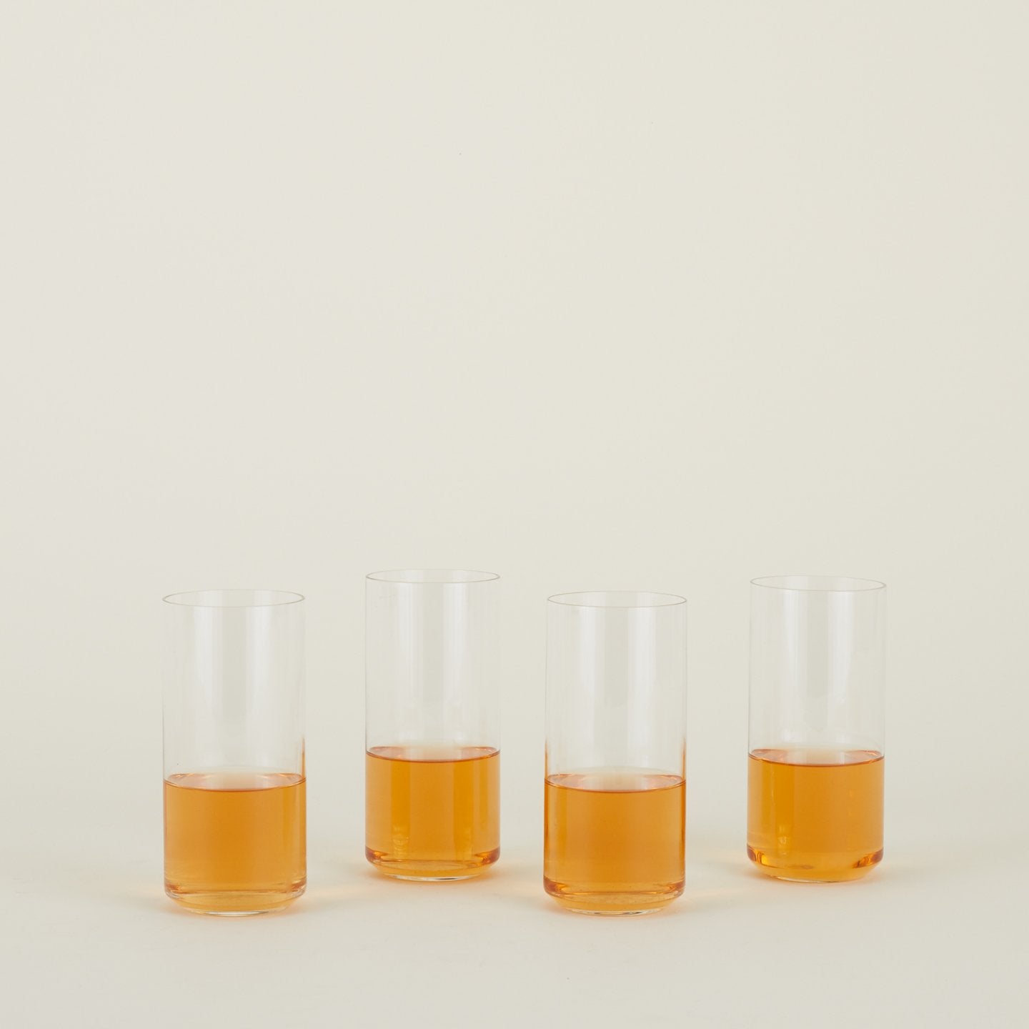 Four clear Simple Glasses in Tall size filled with sparkling wine.