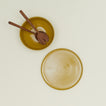Essential Serving Platter and Serving Platter in Mustard, with wood serving utensils.