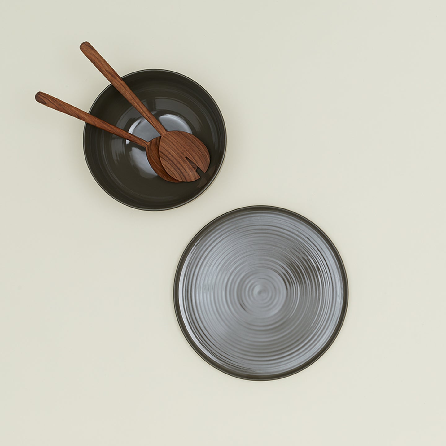 Essential Serving Bowl and Serving Platter in Olive, with wood serving utensils.